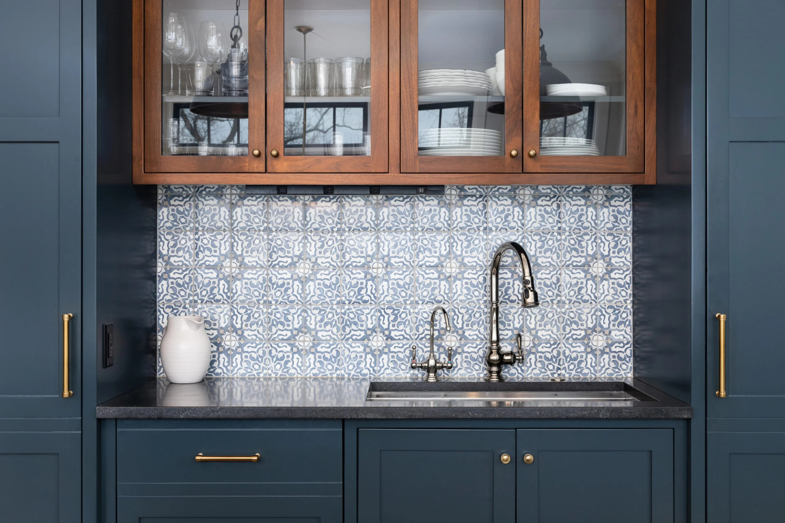 Modern kitchen with blue cabinets, patterned blue and white tiled backsplash and wooden glass-front upper cabinets designed by Kitchen Renovation Company San Francisco, Front Street Builders