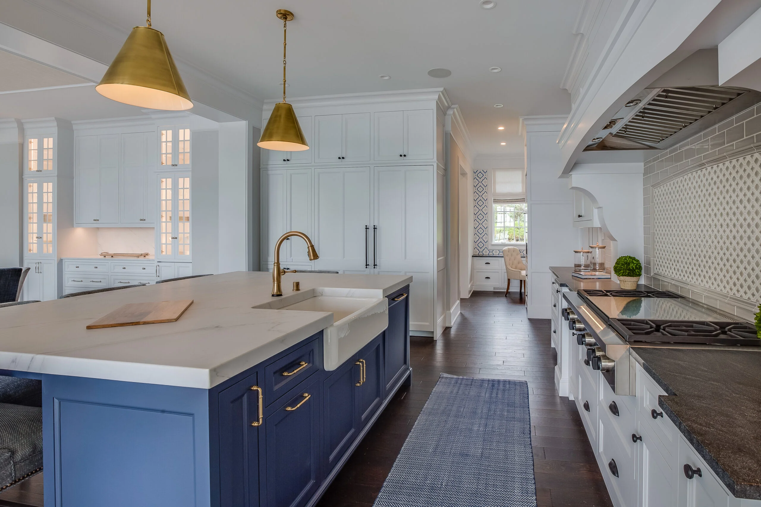Modern kitchen with blue island, brass fixtures, white cabinetry and hardwood floor designed by Best Kitchen Remodeling Company San Francisco, Front Street Builders